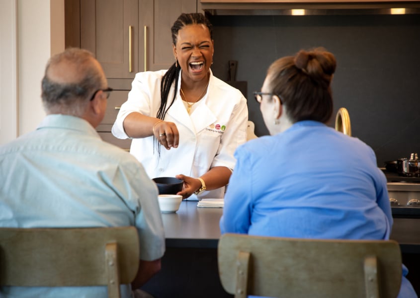 Personal chef prepares meal for senior couple