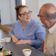 Elderly couple smiling while enjoying a fresh made meal from Chefs For Seniors at the kitchen island in their own home